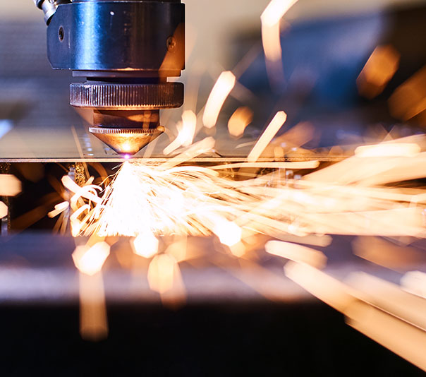 CNC Laser cutting of metal with sparks, modern industrial technology. Small depth of field.