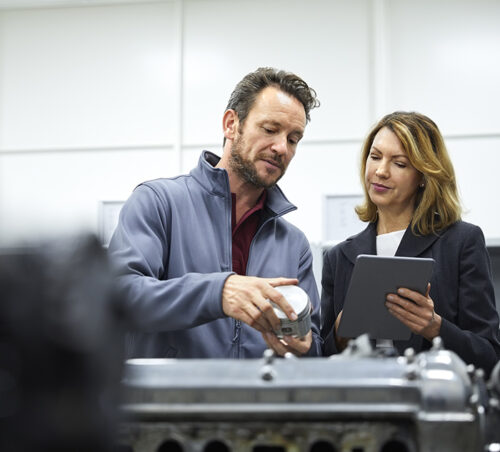 Manager and engineer with tablet PC and piston