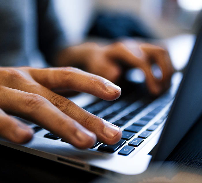Close up man hands typing on a computer laptop keyboard