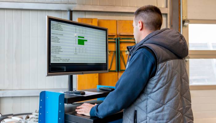 Technician on computer doing data analytics for manufacturing
