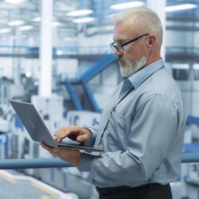 manufacturer standing with a laptop in hand