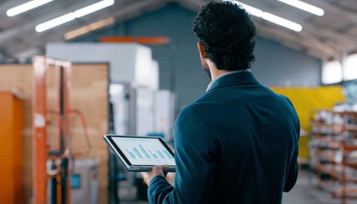 Un fabricant travaillant sur le plancher de l’atelier en utilisant une tablette.